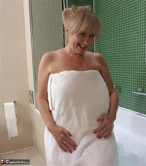 mature woman spreads her pussy lips while taking a bubble bath