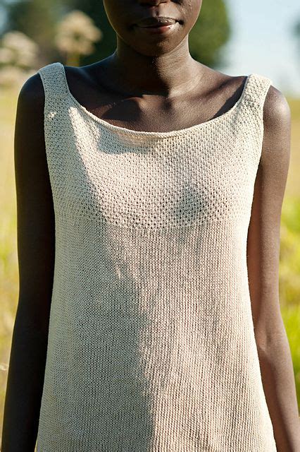 woman standing   grass wearing  white top  holes   chest