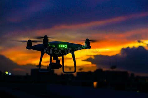 quadcopter drone flying  city building sunset sky  cloud stock image image