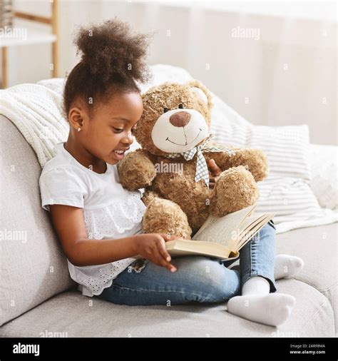 child holding teddy bear  reading book stock photo alamy