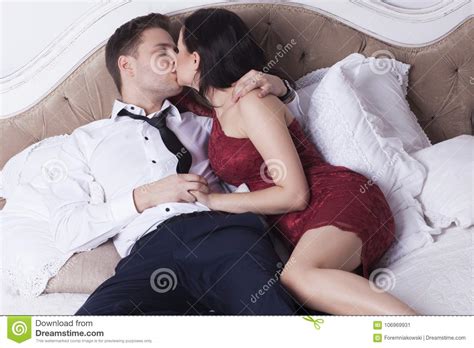 And Elegant Couple Are Kissing In Bedroom Stock Image
