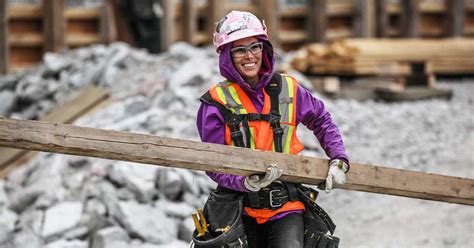 female construction worker carrying beam  worksite innovating canada