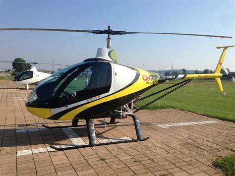 yellow  black helicopter sitting  top   tarmac    field