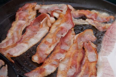 stock photo  bacon strips cooking  frying pan