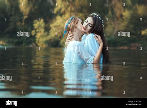 two women lesbians caress each other while standing in water stock