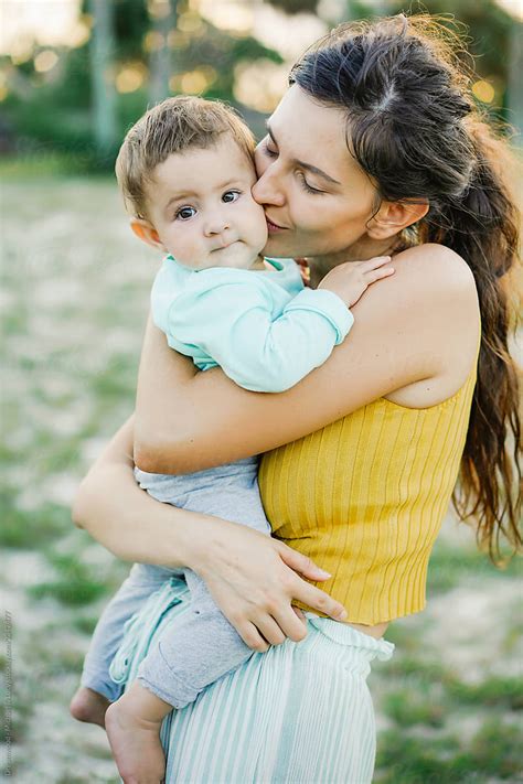 Young Mother Hugging And Kissing Son In Park By Stocksy Contributor