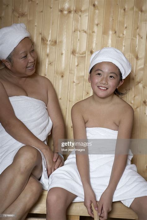 Grandmother And Granddaughter Wrapped In Towels Smile As They Enjoy A