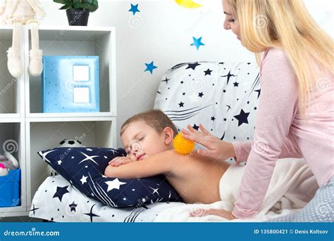 the mother makes the massage of the back of her little son stock image