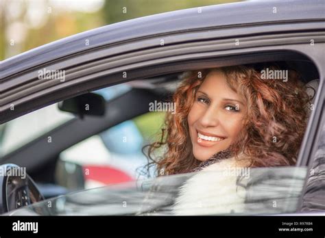 latina girl with blonde hair and sun tanned skin smiling while driving
