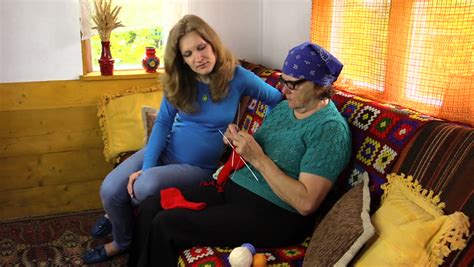 grandma knitting stockings with pregnant granddaughter on sofa stock footage video 10410794