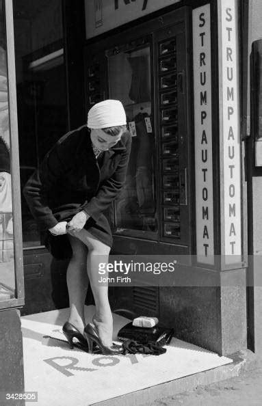 a woman buys a new pair of nylons from a stocking vending machine or