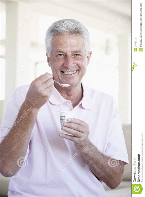 middle aged man eating yogurt stock photography image