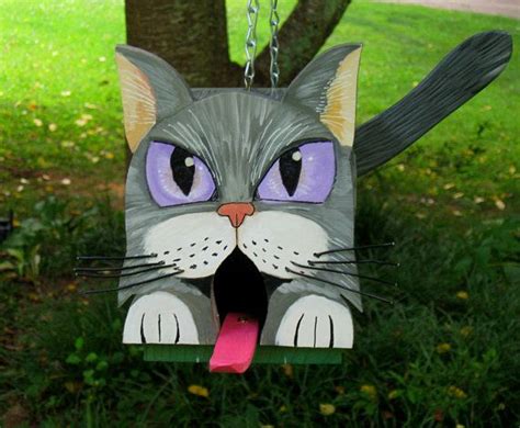 cat shaped birdhouse hanging   tree   grass   tongue
