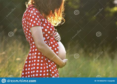 girl in the ninth month of pregnancy in a red dress with