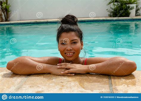 Woman Standing At The Edge Of Swimming Pool In The Backyard At Home
