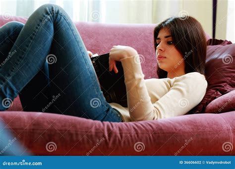 jonge mooie vrouw die op de bank liggen en boek lezen stock foto image  een uitziend