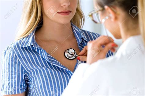 Portrait Of Female Doctor Checking Patient Heartbeat Using Stethoscope