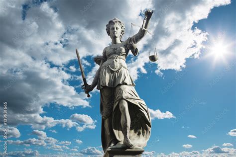 justitia symbol fuer gerechtigkeit vor himmel mit wolken foto de stock