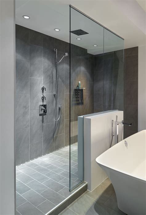 large walk in doorless shower with gray slate tiles and a floating