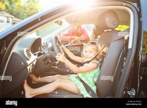 girl sitting  drivers seat car wearing seatbelt pretending