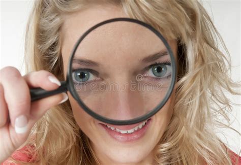 woman looking through a magnifying glass with big eyes stock image