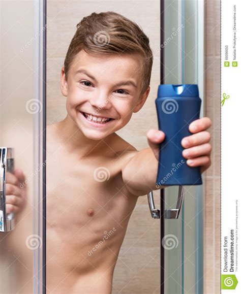 il ragazzo teenager prende una doccia nel bagno fotografia