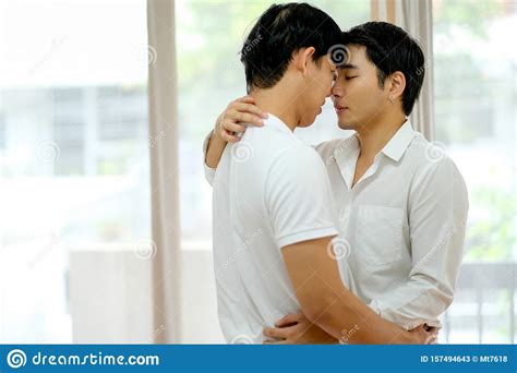 asian gay couple with white shirt kiss together in bed