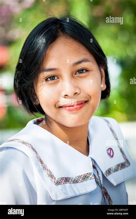a beautiful filipino school girl poses in a park in angeles city