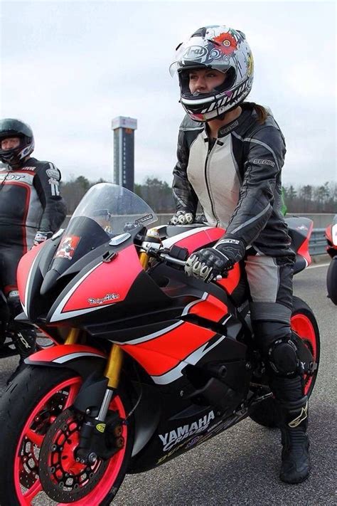 woman sitting  top   red motorcycle    person wearing  helmet