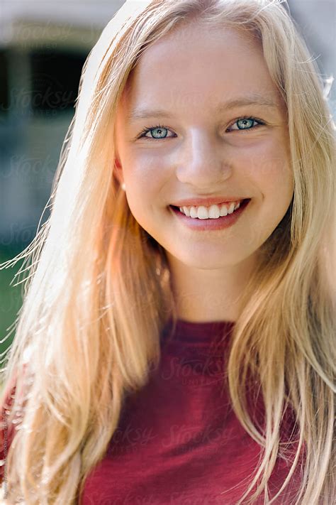 portrait of beautiful blond teen with blue eyes girl smiling stocksy united