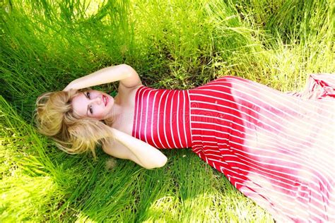 Beauty Woman In Dress Lying On Green Meadow In Grass Stock Image