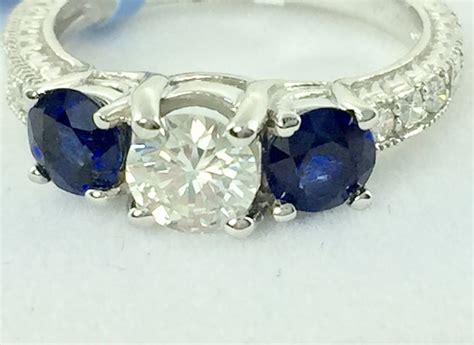 Three Stone Ring With Beautiful Center Diamond Flanked By Two Blue