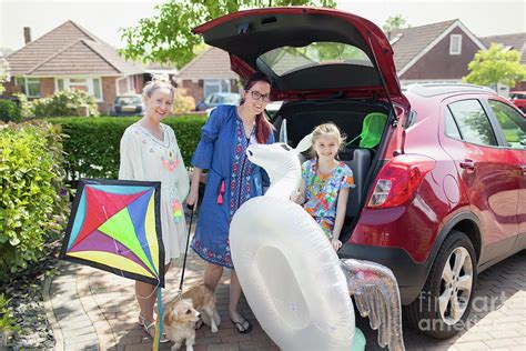 Lesbian Couple And Daughter Loading Car Photograph By Caia Image