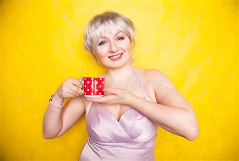 Pretty Curvy Young Blonde Woman With Short Hair Enjoys Drinking Tea
