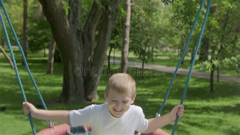 4k Mom Rides Her Son On A Swing In The Park In The Summer Stock