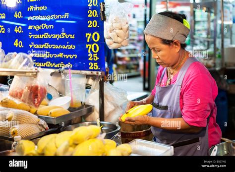 thai lady preparing mango sticky rice dessert at a hawker stand in