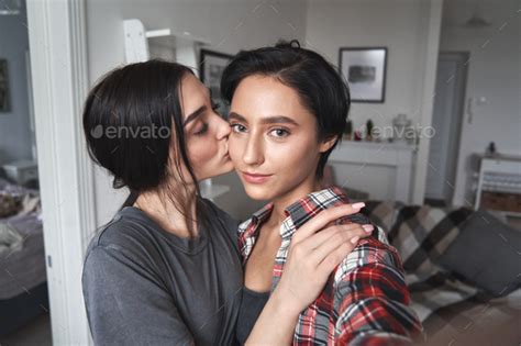 Young Lesbian Couple Kissing Taking Selfie At Home Camera View
