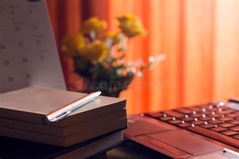 journal intime  labtop pour le travail sur la table en bois avec la fleur  le rideau rouge