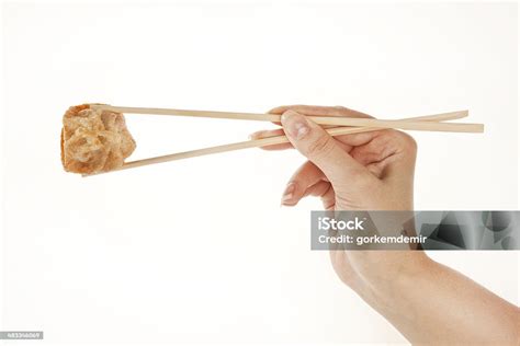 Hand Holding Chinese Wonton Dumpling With Chopsticks Isolated On White