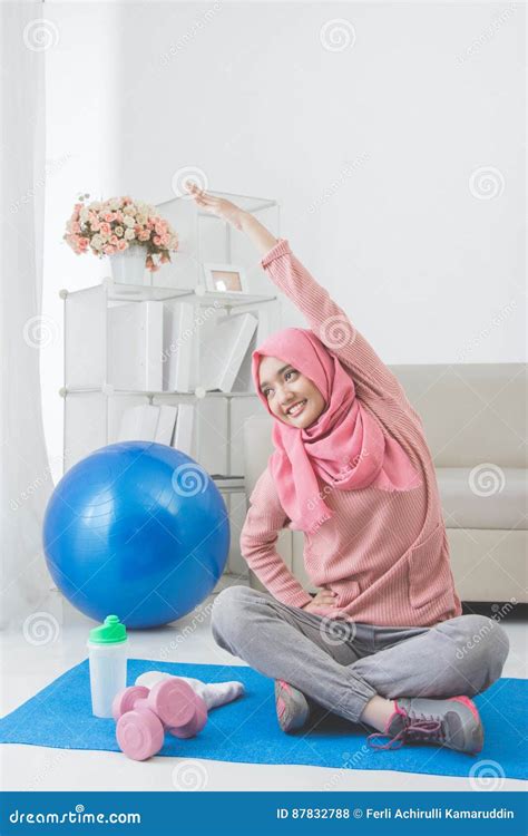 vrouw die terwijl thuis het doen van oefening uitrekken zich stock foto image  indonesisch