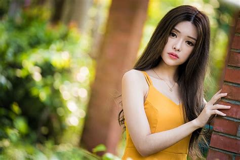 asiático modelo mujer pelo largo morena vestido amarillo collar