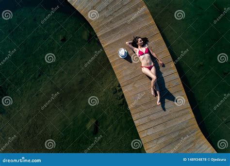 aerial drone view woman  swimsuit sunbathing   pier stock photo image  pier swim