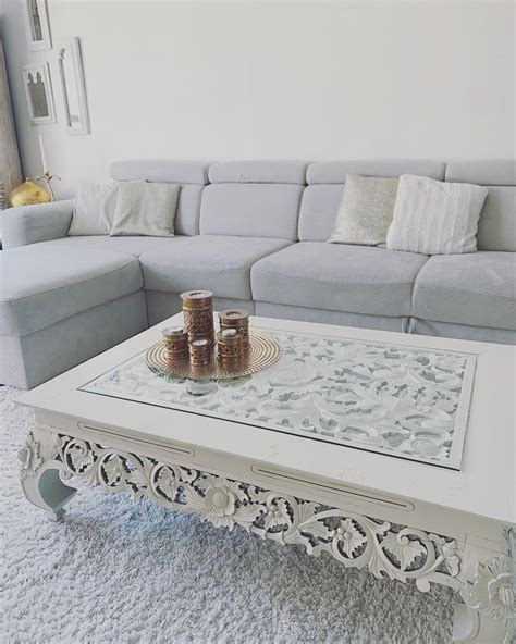 white coffee table sitting  top   carpeted floor    couch