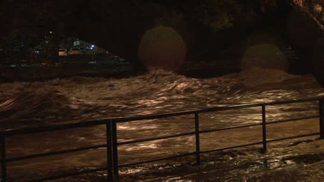 river dangerously overflowing on side walk during heavy rain storm in chiavari italy stock