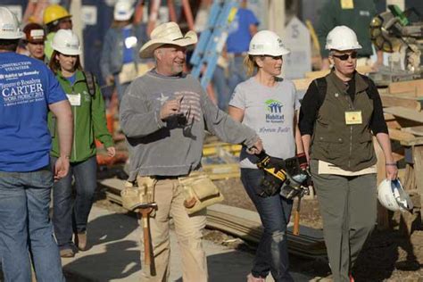 garth brooks and trisha yearwood center work on building a home during habitat for humanity s