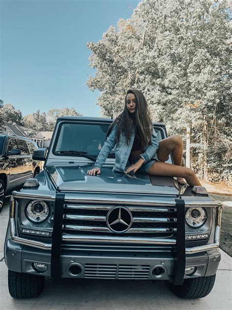 A Woman Sitting On The Hood Of A Mercedes Benz