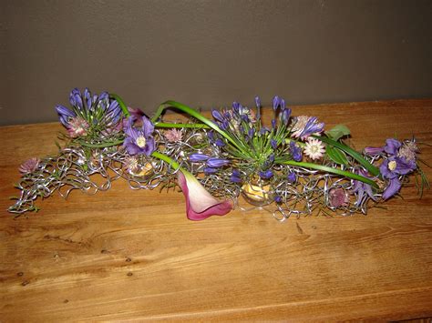 bloemstuk van dik buigzaam ijzerdraad met kleine vaasjes voor de bloemen