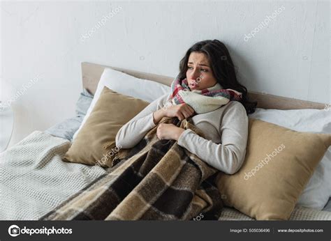 femme malade couchee lit sous une couverture carreaux maison image