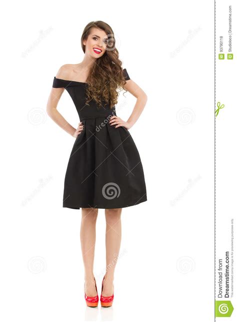elegant woman in black dress is posing with hands on hip