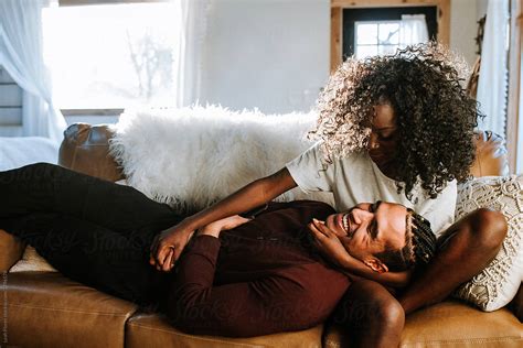 happy couple relaxed on couch by stocksy contributor leah flores